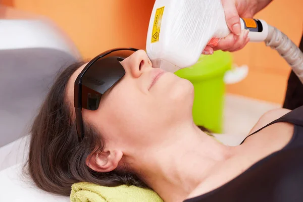 Kosmetička dávat laserové epilace léčbu na mladé ženy si tělo na Beauty Clinic — Stock fotografie