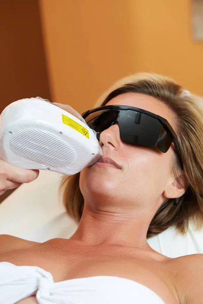 Kosmetolog ger Laser epilering behandling till ung kvinnas kropp på skönhetsklinik — Stockfoto