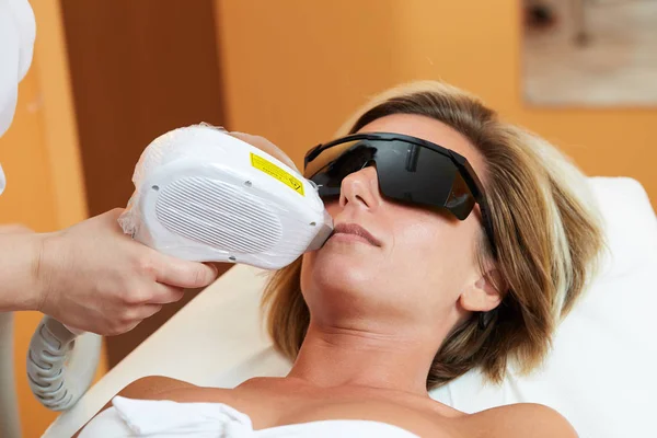 Kosmetička dávat laserové epilace léčbu na mladé ženy si tělo na Beauty Clinic — Stock fotografie