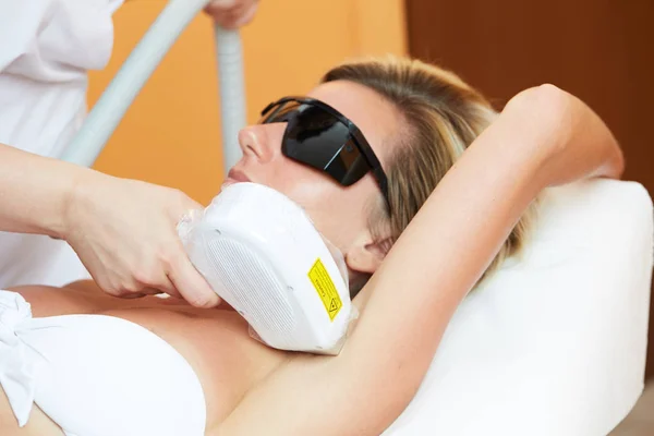 Kosmetička dávat laserové epilace léčbu na mladé ženy si tělo na Beauty Clinic — Stock fotografie