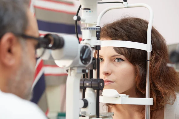 Mooie jonge vrouw met haar ogen onderzocht door een oogarts — Stockfoto