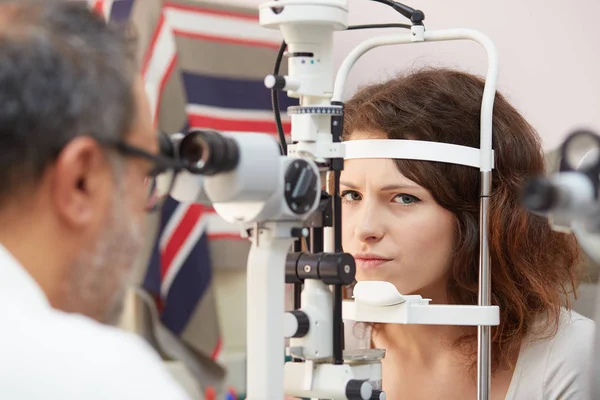 Mooie jonge vrouw met haar ogen onderzocht door een oogarts — Stockfoto