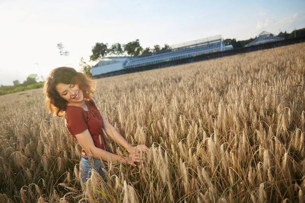 Красивая женщина стоит на пшеничном поле — стоковое фото