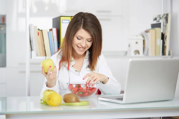 机の上の果物と女性栄養士の概念的な写真 — ストック写真