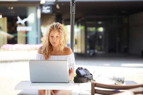 Mulher ao ar livre usando um reflexo digital para tirar fotos e verificar em seu laptop o que ela fez — Fotografia de Stock