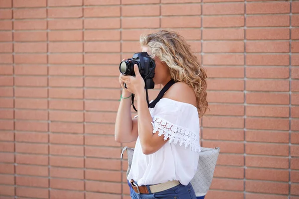 Fille touristique prenant des photos dans une rue — Photo