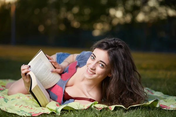 Genç kadın öğrenci kitap okuma açık havada bir zevk