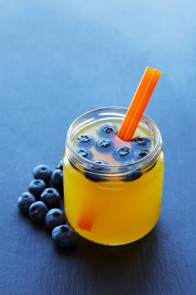 Fresh made lemon Juice drink with blueberries on wooden background — Stock Photo, Image