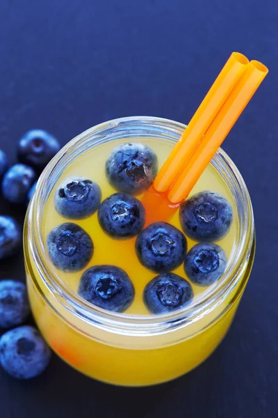 Fresh made lemon Juice drink with blueberries on wooden background — Stock Photo, Image