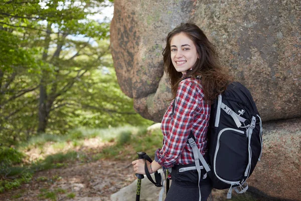 Mulher caminhante sorrindo e andando com postes de caminhada . — Fotografia de Stock