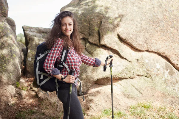 Mulher caminhante sorrindo e andando com postes de caminhada . — Fotografia de Stock