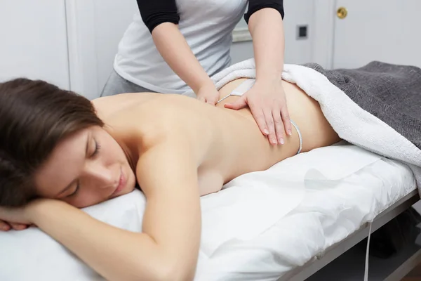 Feminino desfrutando de relaxante massagem nas costas no centro de spa cosmetologia — Fotografia de Stock
