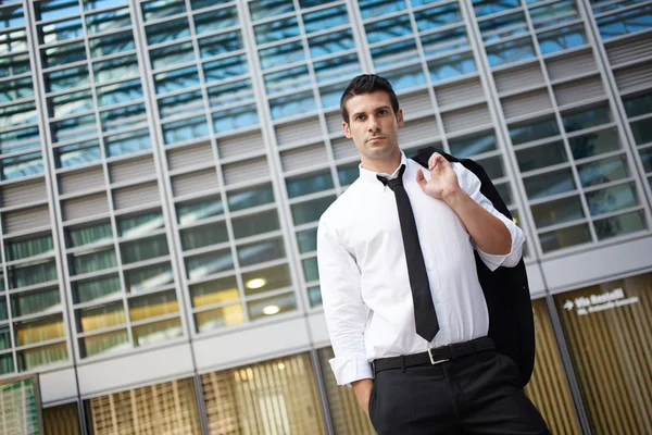 Hombre de negocios guapo de pie fuera del edificio de oficinas — Foto de Stock