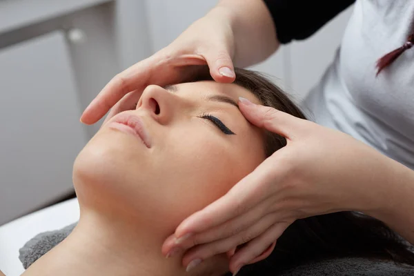 Vrouwelijke genieten van ontspannen gezicht Massage In cosmetologie Spa Center — Stockfoto