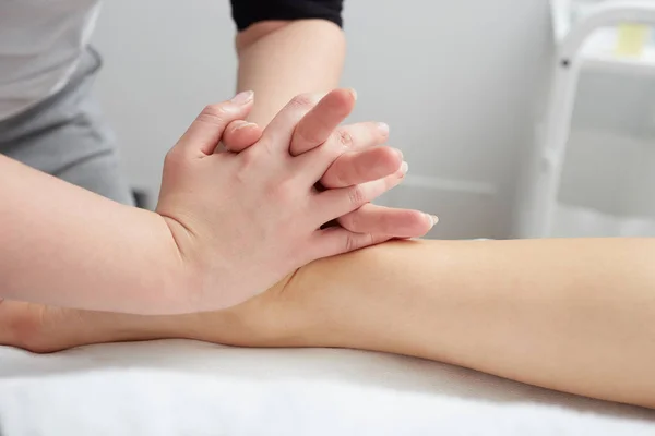 Femme bénéficiant de massage relaxant des jambes dans le centre de spa de cosmétologie — Photo