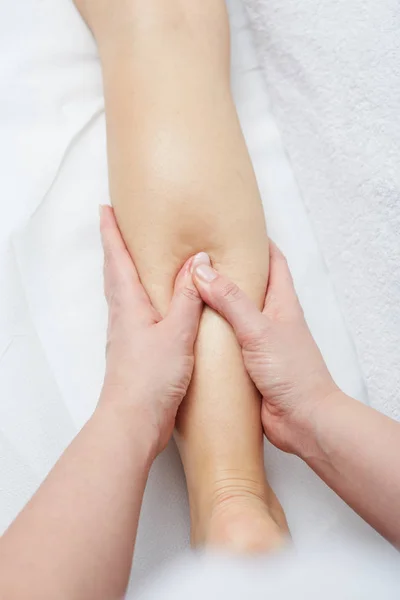 Mujer disfrutando relajante piernas masaje en cosmetología spa centro — Foto de Stock