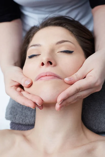 Женский расслабляющий массаж лица в косметологическом спа-центре — стоковое фото