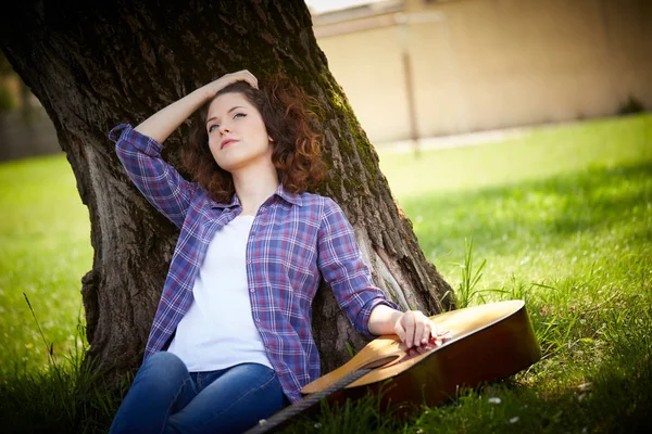 Kvinna spela gitarr i park — Stockfoto