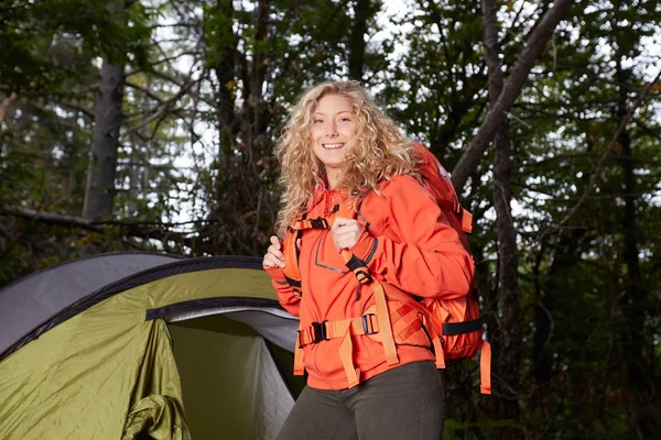 Camping woman in tent using survival knife