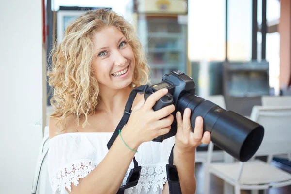 Young woman tourist with camera in her hands — Stock Photo, Image