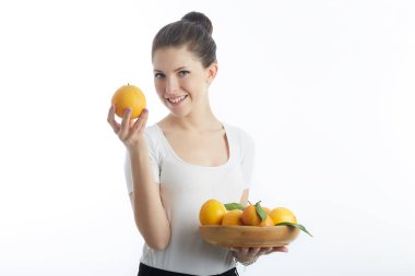 Turuncu meyve tutan genç kadın