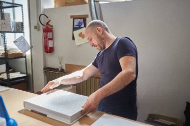 Bir depoda çalışan kitap klasörü.