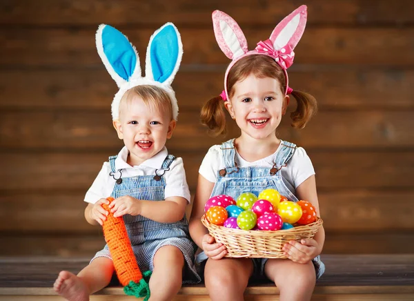Happy kids boy and girl dressed as Easter bunnies with basket of — Stock Photo, Image