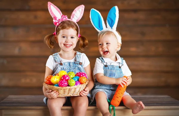 Feliz niño y niña vestidos como conejitos de Pascua con cesta de —  Fotos de Stock