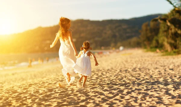 Família feliz na praia. mãe e filho filha correr, rir e — Fotografia de Stock