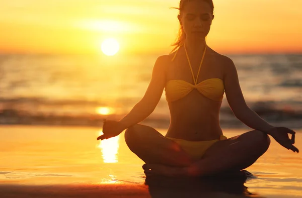Mujer practica yoga y medita en posición de loto en beac —  Fotos de Stock