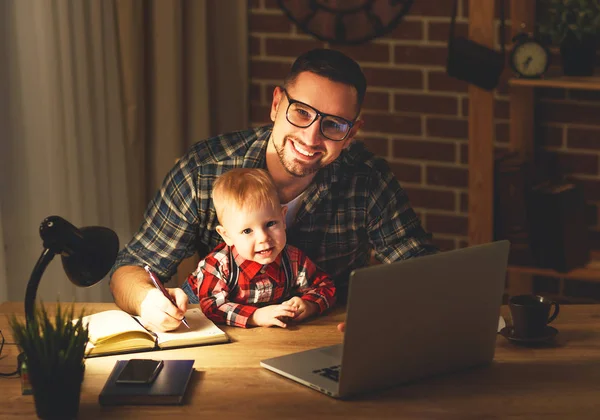 Far och son baby arbete, hemma vid datorn i mörkret — Stockfoto