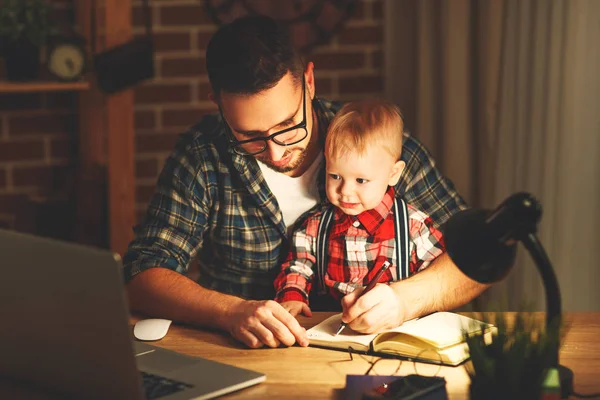 Padre e hijo bebé trabajo en casa en la computadora en la oscuridad — Foto de Stock