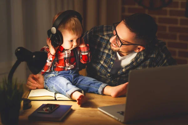 ヘッドフォンで音楽を聴く家族の父親と息子の赤ちゃん — ストック写真