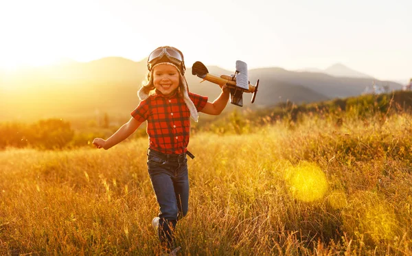 Child pilot aviator with airplane dreams of traveling in summer — Stock Photo, Image