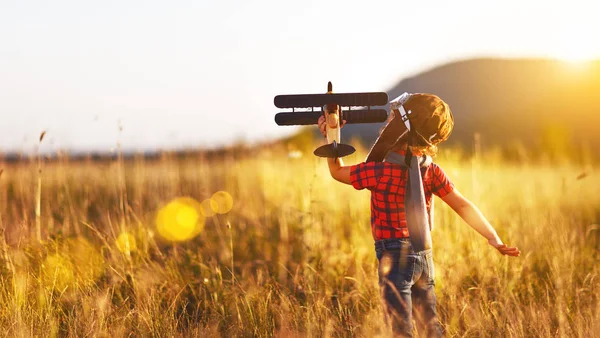 Child pilot aviator with airplane dreams of traveling in summer — Stock Photo, Image