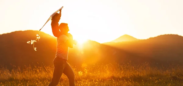 Feliz dia do pai! Criança menina e pai com um papagaio na natureza em — Fotografia de Stock