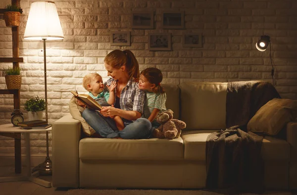 Family before going to bed mother reads children book about lamp — Stock Photo, Image