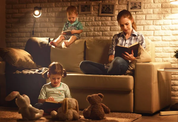 Familie voordat u naar bed moeder en kinderen lezen boeken en pl — Stockfoto