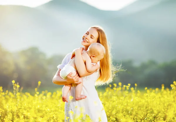Gelukkige familie moeder en baby knuffelen aard in de zomer — Stockfoto