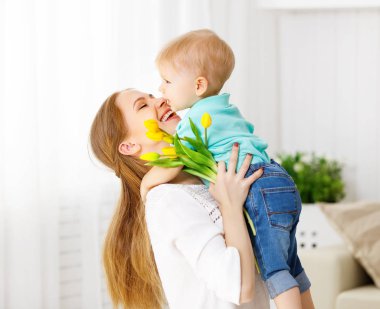 Mutlu anneler günü. Bebek evlat anne için çiçek verir