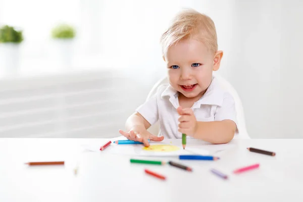 Щасливий хлопчик малює кольоровим олівцем — стокове фото