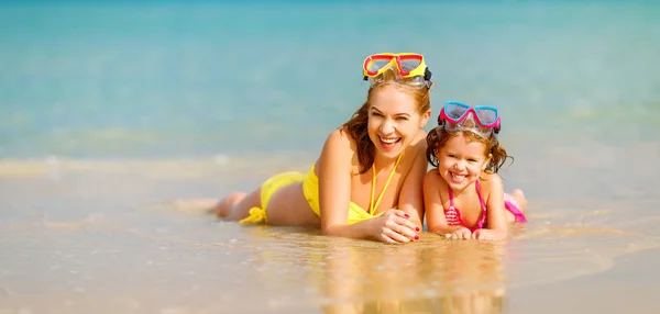 Feliz familia madre y chid hija en máscaras en playa en summe — Foto de Stock