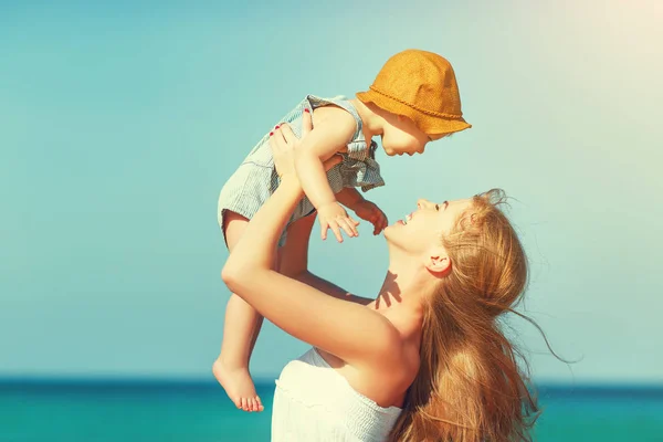 Feliz familia madre con bebé hijo camina por el océano en la playa en suma —  Fotos de Stock