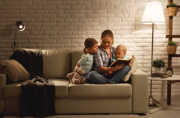 Family before going to bed mother reads children book about lamp — Stock Photo, Image