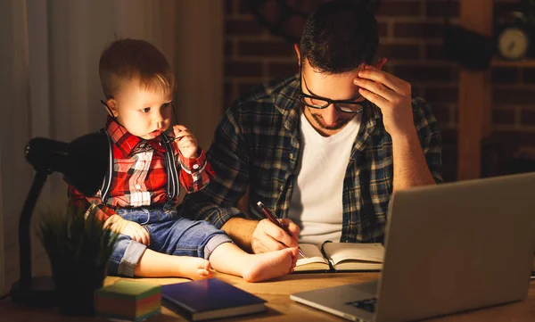 Padre e hijo bebé trabajo en casa en la computadora en la oscuridad — Foto de Stock