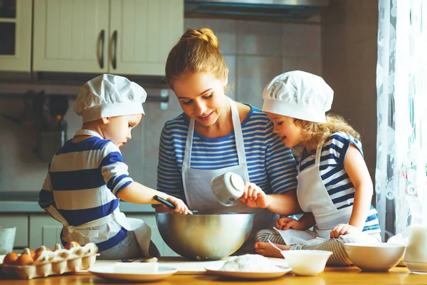 Happy family in kitchen. mother and children preparing dough, ba — Stock Photo, Image