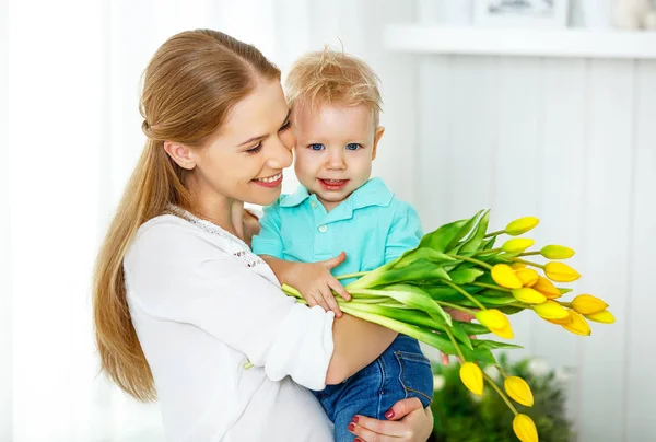 Happy mother\'s day. Baby son gives flowers for mom