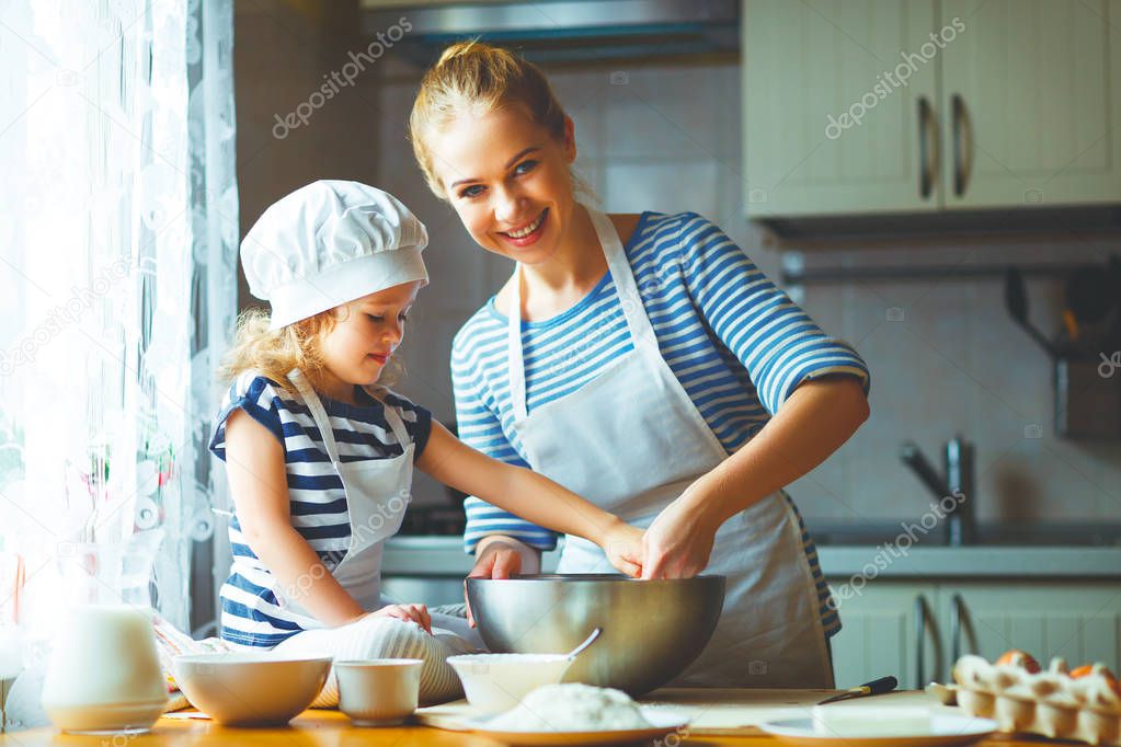 happy family in kitchen. mother and child preparing dough, bake 
