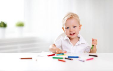 Mutlu bebek çocuk renkli kalemle çizer