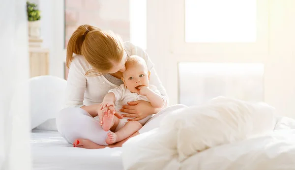 Gelukkige familie moeder en baby spelen, knuffelen in bed — Stockfoto